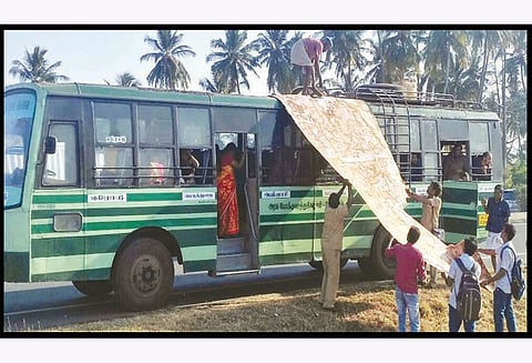 பெருந்துறை அருகே அரசு பஸ்சின் மேற்கூரையில் பதித்த தார்பாய் பறந்தது