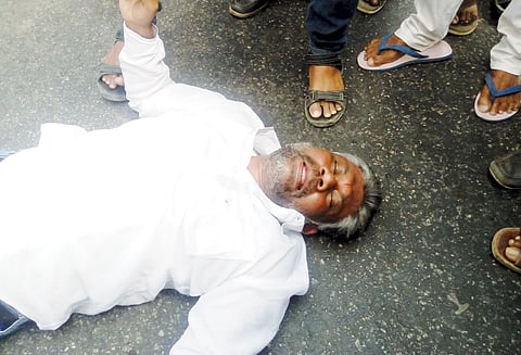 தேசிய நெடுஞ்சாலையில் படுத்துக் கொண்டு போராட்டத்தில் ஈடுபட்ட முன்னாள் நகரசபை உறுப்பினர்