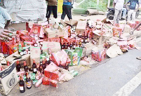 மதுபாட்டில் பெட்டிகள் சரிந்து விழுந்ததால் சாலையில் பெருக்கெடுத்து ஓடிய மதுபானம்