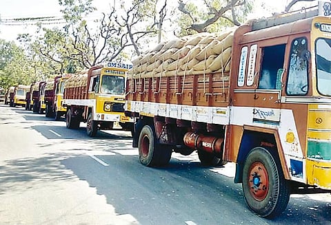 திறந்தவெளி சேமிப்பு மையத்தில் ஆட்கள் பற்றாக்குறையால் நெல்மூட்டைகளுடன் வரிசையில் நிற்கும் லாரிகள்
