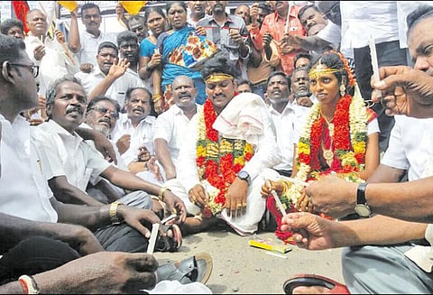 மணக்கோலத்தில் புதுமண தம்பதிகள் சாலை மறியல்