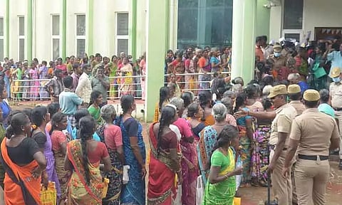 பாதுகாப்பு உபகரணங்கள் வாங்குவதற்கு குவிந்த கட்டுமான தொழிலாளர்கள்