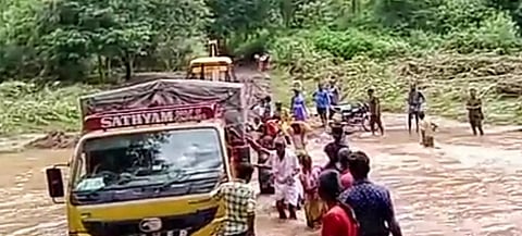 கடம்பூர் அருகே காட்டாற்று வெள்ளத்தில் சிக்கிய லாரி; டிராக்டரில் கயிறு கட்டி மீட்டனர்