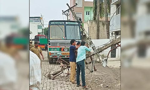 மின்கம்பங்கள் சாய்ந்து டேங்கர் லாரி மீது உயர்மின் அழுத்த கம்பிகள் விழுந்ததால் பரபரப்பு - வாகன ஓட்டிகள், பொதுமக்கள் அலறி அடித்து ஓட்டம்