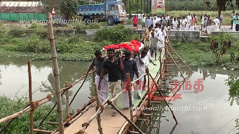 கோபி அருகே ஓடையின் குறுக்கே தற்காலிக பாலம் அமைத்து இறந்தவரின் உடலை சுமந்து சென்ற உறவினர்கள்- நிரந்தர பாலம் கட்ட கோரிக்கை