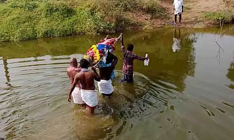 இடுப்பளவு தண்ணீரில் இறந்தவரின் உடலை சுமந்து செல்லும் அவலம்