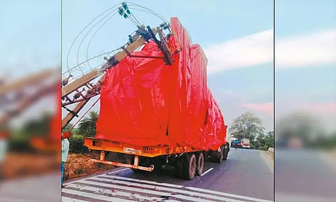 ஏற்றி சென்ற எந்திரம் மின் கம்பியில் சிக்கி லாரி மீது டிரான்ஸ்பார்மர் விழுந்தது - போக்குவரத்து பாதிப்பு