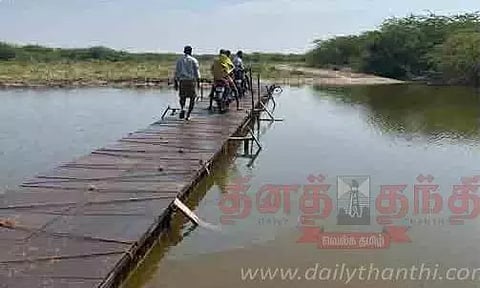 திருமங்கலம் மைக்குடி கண்மாயை மரப்பாலத்தில் பீதியுடன் கடக்கும் விவசாயிகள்- பாலம் கட்டி தர கோரிக்கை