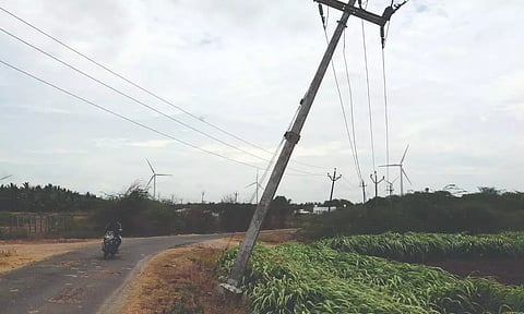 விளைநிலங்களில் சரிந்து விழும் நிலையில் உள்ள மின் கம்பங்களால் விபத்து அபாயம்
