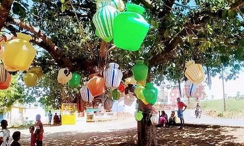 குடங்களை மரத்தில் தொங்கவிட்டு கிராம மக்கள் நூதன போராட்டம்