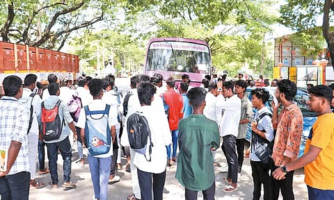 திருத்தணியில் பஸ் படிக்கட்டில் தொங்கியபடி கல்லூரி மாணவர்கள் ஆபத்தான பயணம் - பாதி வழியில் நிறுத்தியதால் மறியல் போராட்டம்