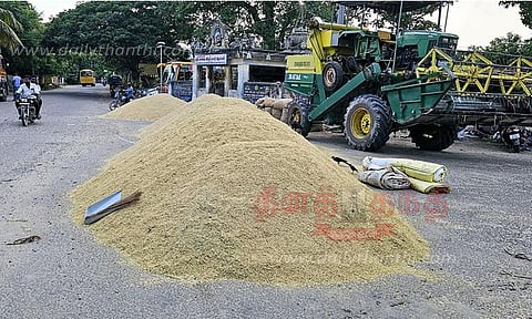 அறுவடை செய்த நெல்லை சாலையில் உலர வைக்கும் விவசாயிகள்