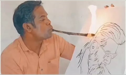 வாயில் நெருப்புடன் கூடிய குச்சியை பிடித்தபடி அஜித்தை வரைந்த ஓவியர்
