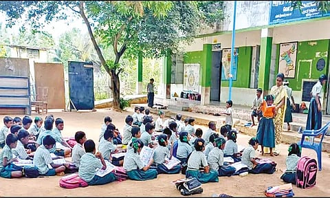 போதிய பள்ளி கட்டிடம் இல்லாததால் மரத்தடியில் பாடம் படிக்கும் மாணவர்கள்
