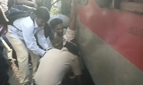ஓடும் ரெயிலில் இருந்து இறங்க முயன்ற பயணி: ரெயிலுக்கு இடையே சிக்கி கொண்டதால் பரபரப்பு