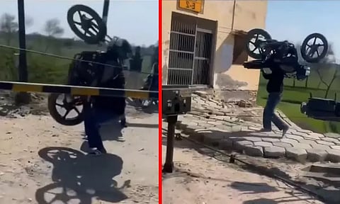 பாகுபலிக்கே சவால் விடுவது போல்... பைக்கை தூக்கி சென்ற நபர்; வைரலான வீடியோ