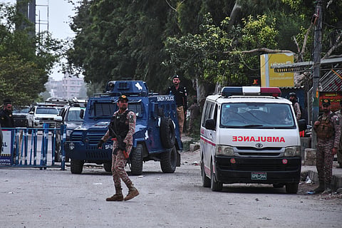 Paramilitary soldiers and police officers stand guard on a road cordoned off near the site of a militant attack at the provincial headquarters of the paramilitary Pakistan Rangers in Karachi, Pakistan, 28 June 2026.