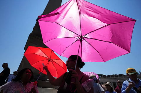 People shelter from the sun with umbrellas as they wait for the Angelus noon prayer celebrated by Pope Leo XIV from the window of his studio overlooking St.Peter's Square, at the Vatican, Sunday, June 28, 2026.