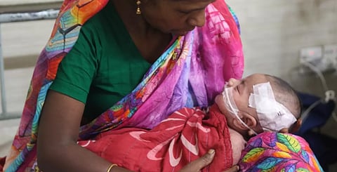 A mother holds her child suffering from measles in a hospital.
