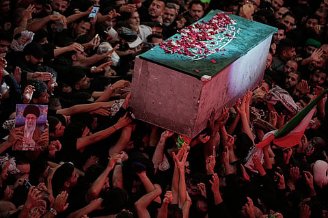 The flower petal-covered coffin of the late Iranian Supreme Leader Ayatollah Ali Khamenei is carried above mourners reaching out to touch it outside the Imam Hussein Shrine in Karbala, Iraq, early Thursday, 9 July 2026.