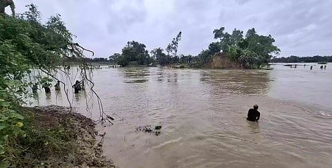 Flood-hit residents struggle through waist-deep water after the Khowai River embankment breached in Habiganj.