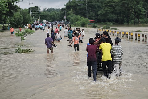 People wade through flood water in Bandarban on Saturday.