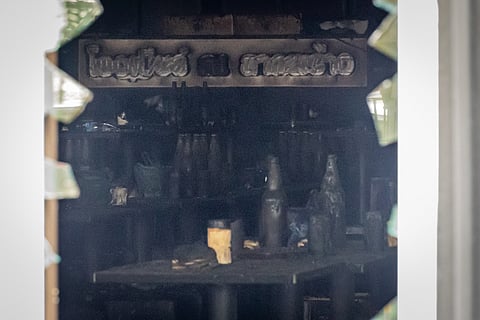 Bottles are seen sitting atop burned tables inside the music bar where a fire killed a number of people in Bangkok, Thailand,14 July 2026.