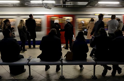 People wait as a tube train arrives at Westminster station in London January 25, 2016.