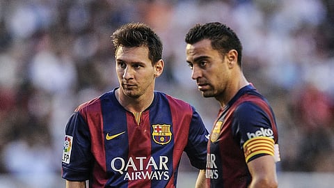 Lionel Messi (L), and Xavi Hernandez playing for Barcelona