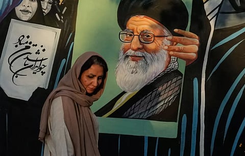 A woman walks past a mural depicting a portrait of the late Iranian Supreme Leader Ayatollah Ali Khamenei, who was killed in the U.S. and Israel strike on Feb. 28, in downtown Tehran, Iran, Saturday, July 18, 2026.