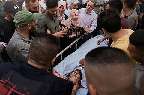 People mourn over the body of Jawad Ramadan, who, according to the Palestinian Health Ministry, was killed by Israeli forces near the village of Tell, after his body was brought to Nablus Speciality Hospital in the West Bank city of Nablus, Friday, July 24, 2026.