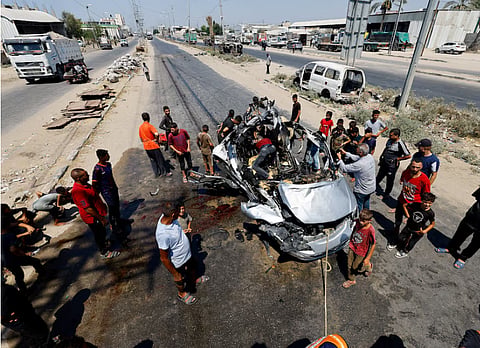 Palestinians inspect the site of an Israeli strike on a vehicle, according to medics, in Deir al-Balah in the central Gaza Strip, August 2, 2026.