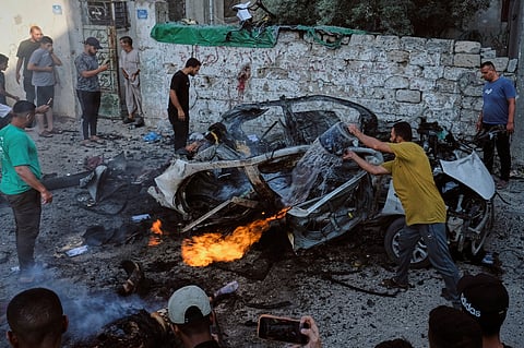 Palestinians try to extinguish a burning car after an Israeli military strike in Gaza City, Sunday, Aug 2, 2026.