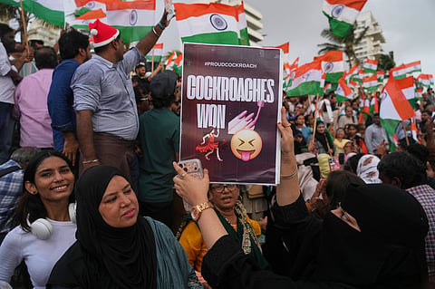 A protester holds a placard after India's Education Minister Dharmendra Pradhan resigned following nationwide protests as part of the Cockroach Janta Party's protest movement in Mumbai, India, Saturday, July 25, 2026.