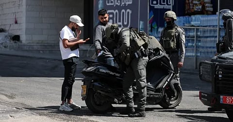 Israeli soldiers inspect a motorcycle during a military raid in the Qalandiya refugee camp in the occupied West Bank on Aug 6, 2026.