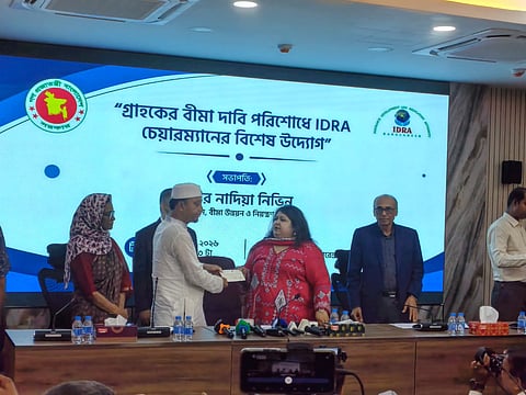 IDRA Chairman Mir Nadia Nivin hands over insurance claim payments to policyholders at a programme in Dhaka on Thursday.