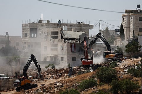 Israeli machinery guarded by Israeli forces demolishes a Palestinian house near Hebron, in the Israeli-occupied West Bank, July 11, 2024.