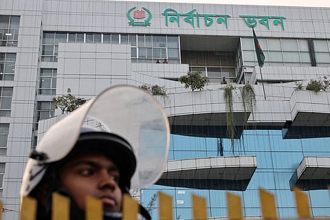 A police officer stands guard in front of the Bangladesh Election Commission office ahead of the expected general election schedule announcement, in Dhaka, Bangladesh, December 11, 2025