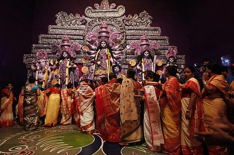 Hindu women wait in a queue to offer sweets and take blessings from Hindu goddess Durga on the last day of the Durga Puja festival in New Delhi October 14, 2013.