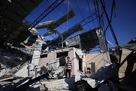 A Palestinian young man stands amid the debris of Al-Hassayna family’s company warehouse, damaged during the war, in Gaza City, September 28, 2026.