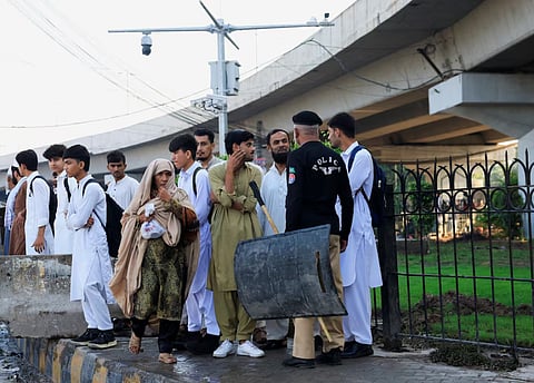 A police officer stops people to access the area near Red Zone, a day after Pakistan imposed a state of emergency in Khyber Pakhtunkhwa province, effectively suspending the provincial government run by jailed former Prime Minister Imran Khan's party, in Peshawar, Pakistan, October 12, 2026.