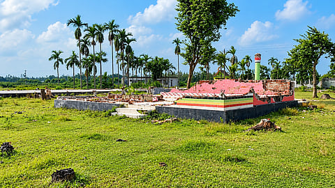 The remains of a demolished structure at Murshidpur Darbar Sharif in Sherpur, surrounded by tree stumps and surviving palms. The religious compound suffered extensive damage during a series of attacks in November 2024