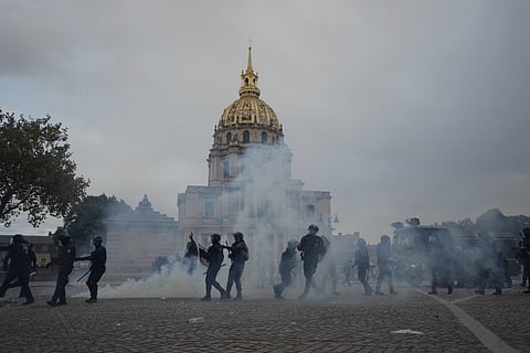 A person holds a French national flag during a protest against under-resourced schools in Paris, Thursday, Oct 8, 2026.