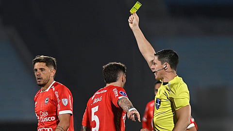 A referee uses a digital device instead of a yellow card during a Uruguayan cup match in a trial to modernise football officiating.