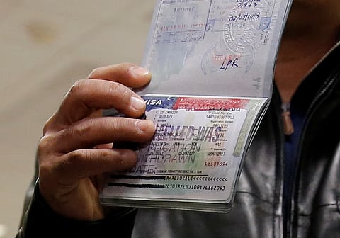 A person shows a cancelled visa in their passport, at Washington Dulles International Airport in Chantilly, Virginia, US February 6, 2017.