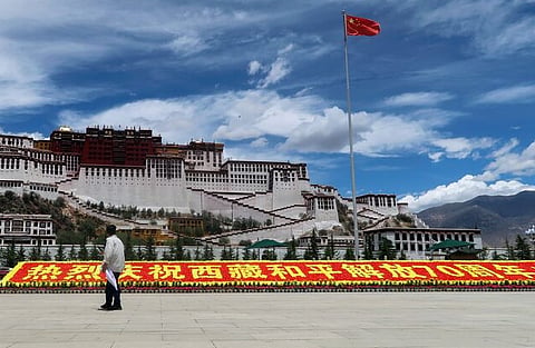 A man stands in front of a sign marking 70 years since Chinese rule over Tibet Autonomous Region, on the Potala Palace Square during a government-organised media tour to Lhasa, Tibet Autonomous Region, China June 1, 2021. Picture taken June 1, 2021.