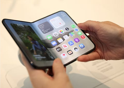 A person uses the new foldable Apple iPhone Duo, on its launch day at an Apple store, in London, Britain, October 23, 2026.
