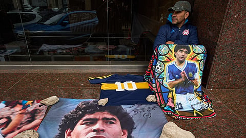 A Diego Maradona fan sits outside the court trying his medical team for alleged negligent homicide in San Isidro, Argentina, on 21 October 2026.