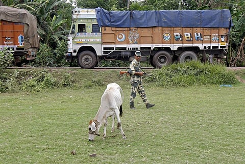 An Indian Border Security Force (BSF) soldier patrols as trucks wait to cross the India-Bangladesh check-post in West Bengal, June 20, 2015