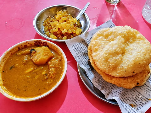 Freshly fried, golden luchis served with a rich, spiced vegetable curry and sweet boondi at Jorakali Mistanna Bhandar in Rajshahi’s Malopara neighbourhood